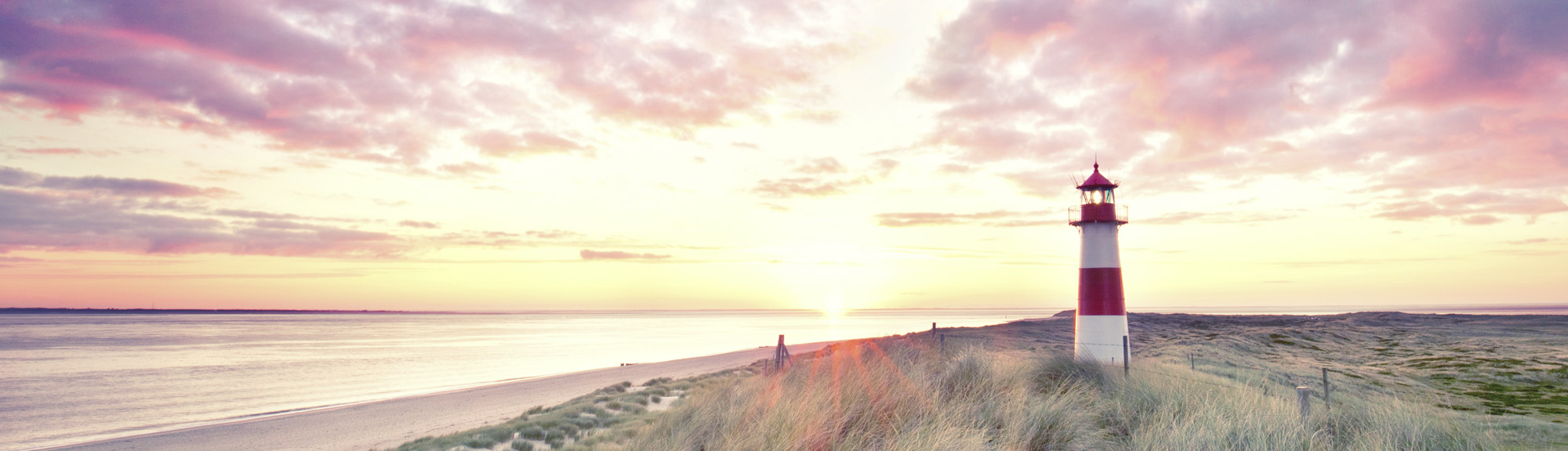 Leuchtturm am Strand im Abendlicht